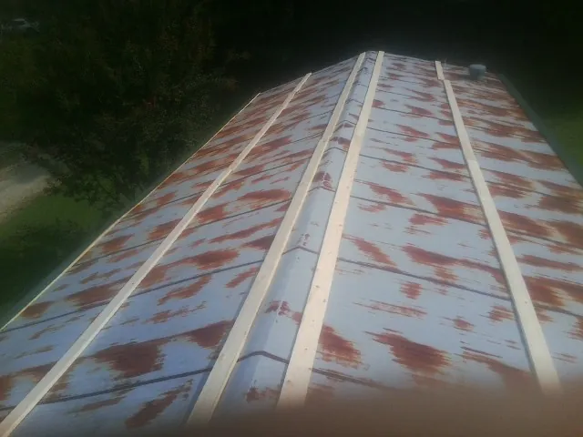 Rusted metal roof panels with new wood purlins before replacement — Storm Damage Roof Repair in Bettendorf by Roofing Brothers