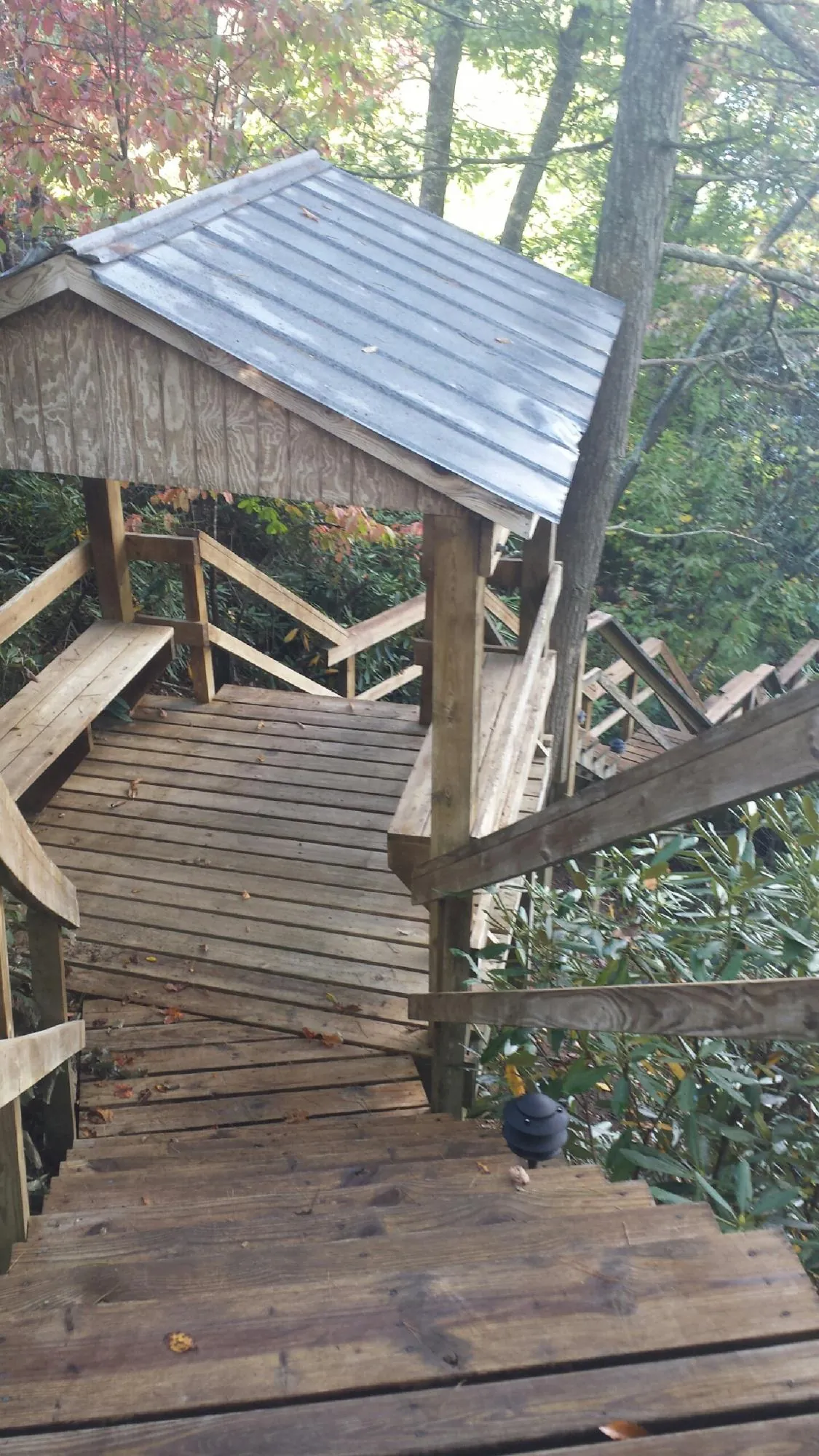 Metal roofed shelter over wooden steps on a wooded walkway — Skylight Repair & Installation work by our crew in Bettendorf