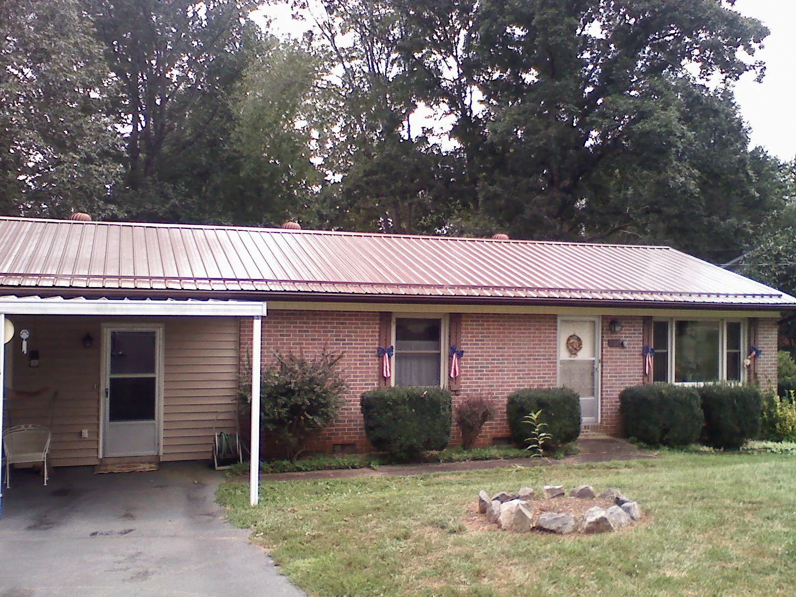 Bronze metal roof and carport on a brick ranch home — Roof Repair work by our crew in Bettendorf