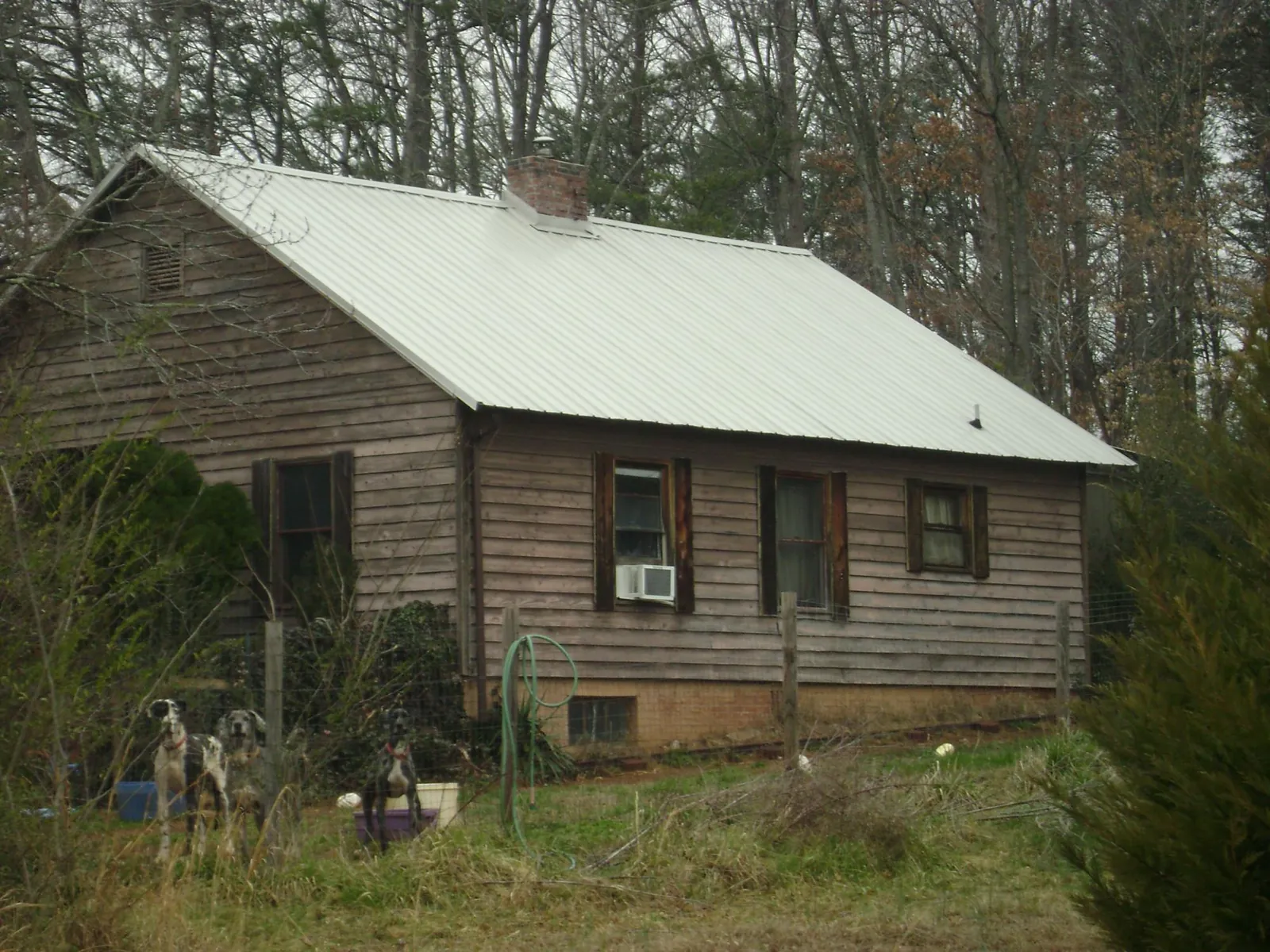 White metal roof on an old wood sided farmhouse, from a Asphalt Shingle Roof Repair job in Bettendorf